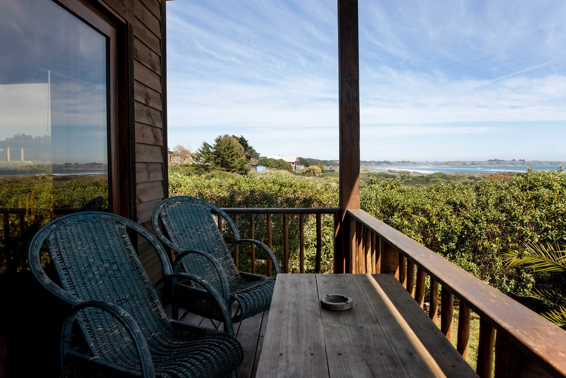 Terraza con sillones de mimbre y vista al mar